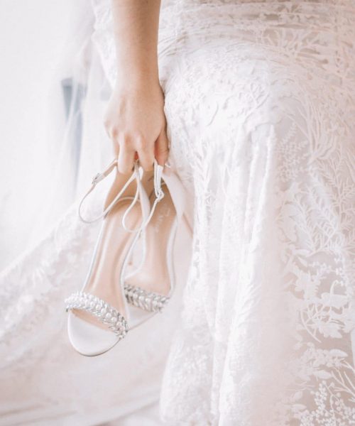 woman-in-white-gown-carrying-white-sandals-2085523